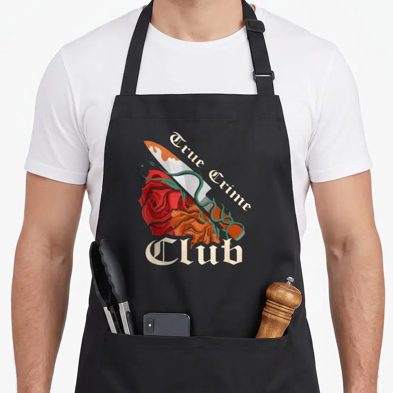 Tablier de cuisine noir avec illustration couteau rosesTrue Crime Club en lettres blanches gothiques.