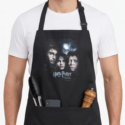 Tablier de cuisine noir avec illustration des personnages et titre du film en typographie stylisée bleue.