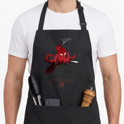 Tablier de cuisine noir avec silhouette rouge de Spider-Man, skyline urbain et texte SPIDER-MAN en bas.