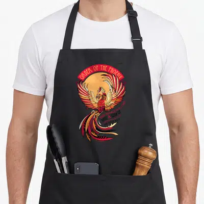 Tablier de cuisine noir avec un phénix aux ailes déployées et le texte Order of the Phoenix en haut.