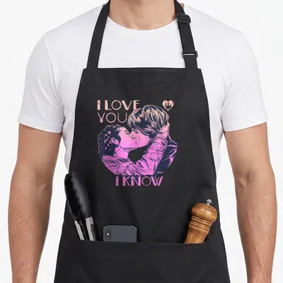 Tablier de cuisine noir avec illustration rose de Han et Leia s'embrassant sous les textes « I Love You » et « I Know ».