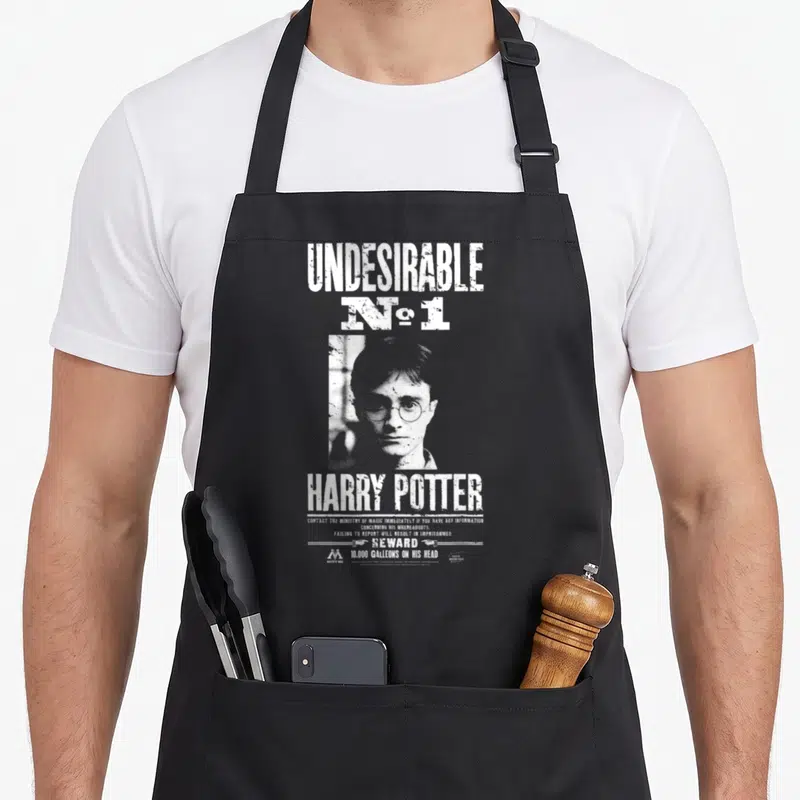 Tablier de cuisine noir avec une affiche blanche représentant un portrait et le texte Indesirable No 1 Harry Potter.