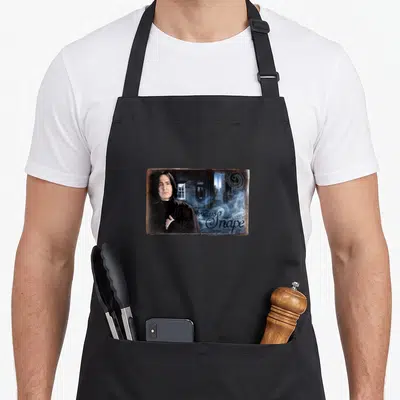 Tablier de cuisine noir avec portrait de Severus Rogue et texte décoratif sur fond d'architecture gothique bleutée.