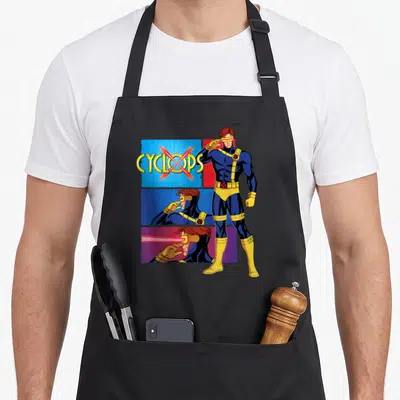 Tablier de cuisine noir avec illustration de Cyclops en tenue bleue et jaune et texte Cyclops barré d'une croix rouge.