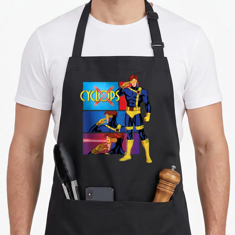 Tablier de cuisine noir avec illustration de Cyclops en tenue bleue et jaune et texte Cyclops barré d'une croix rouge.
