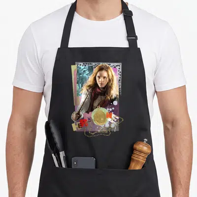 Tablier de cuisine noir avec un collage coloré d'Hermione Granger tenant une baguette et un pendentif doré.