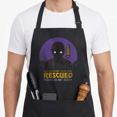 Tablier de cuisine noir avec illustration stylisée du droïde K-2SO sur fond violet et texte jaune en anglais.