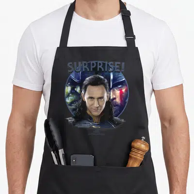 Tablier de cuisine noir avec illustration de Loki et le texte Surprise. en référence au film Thor Ragnarok.