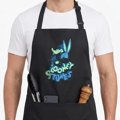 Tablier de cuisine noir avec un collage de personnages Looney Tunes aux teintes bleues et vertes sur le devant.