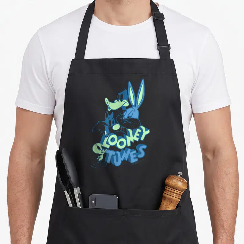 Tablier de cuisine noir avec un collage de personnages Looney Tunes aux teintes bleues et vertes sur le devant.