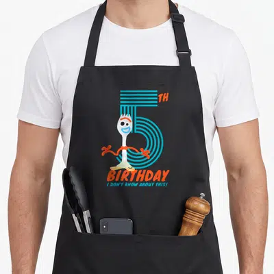 Tablier de cuisine noir avec Fourchette, le chiffre 5 et les mots anniversaire I don't know about this imprimés en couleur.