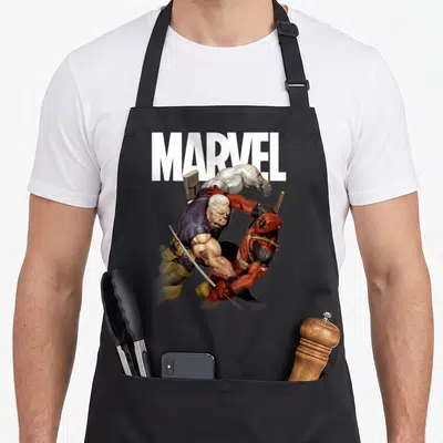 Tablier de cuisine noir avec illustration de Deadpool et Cable en pleine bagarre sous le logo Marvel blanc.