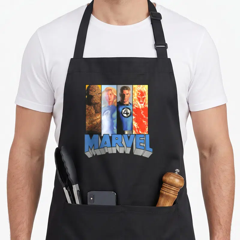 Tablier de cuisine noir avec illustration colorée des Quatre Fantastiques et le logo Marvel en bas.
