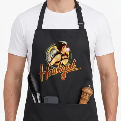 Tablier de cuisine noir avec illustration Hawkgirl Bombshells soufflant une bulle rose et logo vintage.