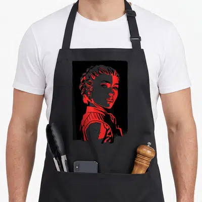 Tablier de cuisine noir avec portrait stylisé de Yelena Belova aux teintes rouges et grises.