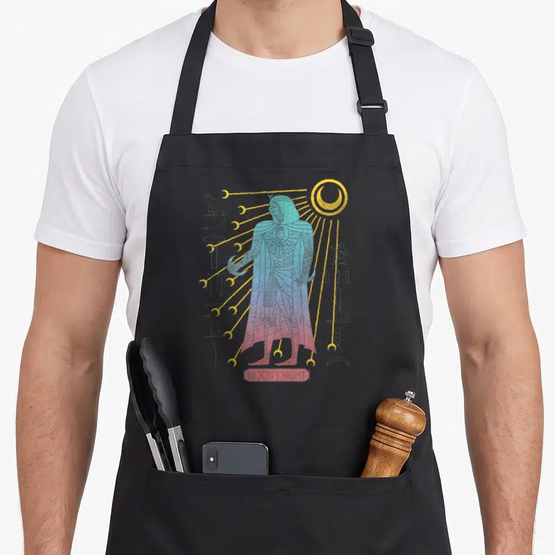 Tablier de cuisine noir avec Moon Knight stylisé en figure égyptienne aux couleurs dégradées et symboles hieratiques.