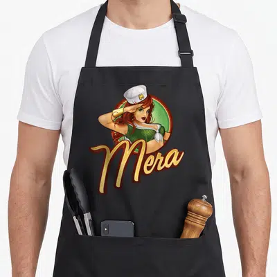 Tablier de cuisine noir avec illustration vintage de Mera en uniforme naval et son nom en lettres dorées