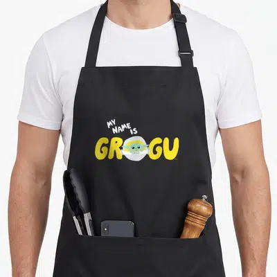 Tablier de cuisine noir avec illustration de Grogu et le texte My Name is Grogu en jaune.