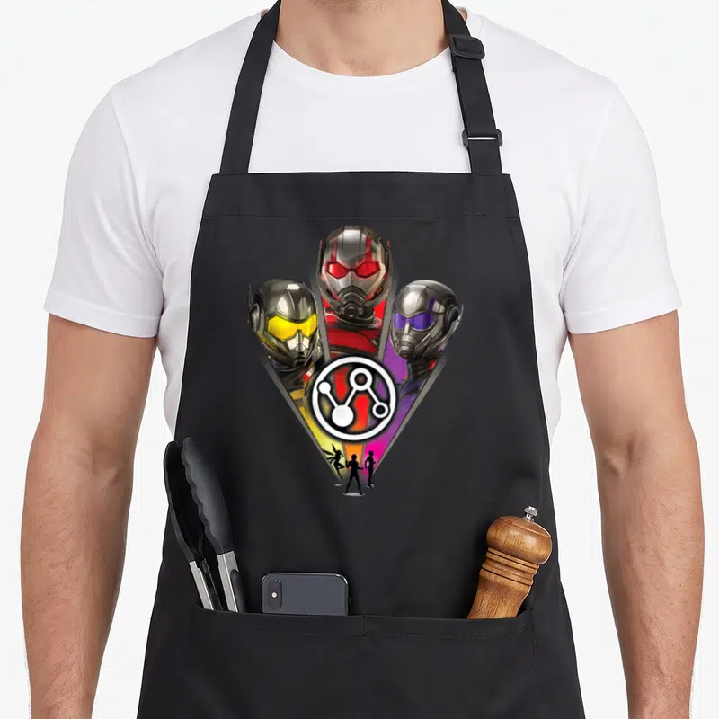 Tablier de cuisine noir avec les casques d'Ant-Man, La Guêpe et un personnage au logo quantique central.