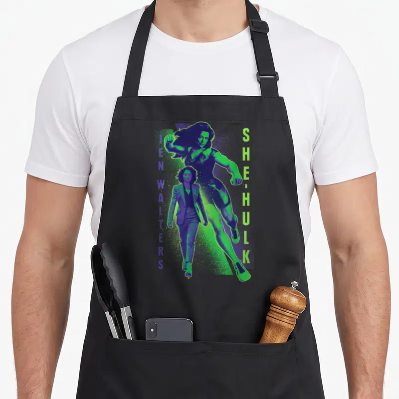 Tablier de cuisine noir avec illustration bicolore de She-Hulk et Jen Walters en position dynamique.