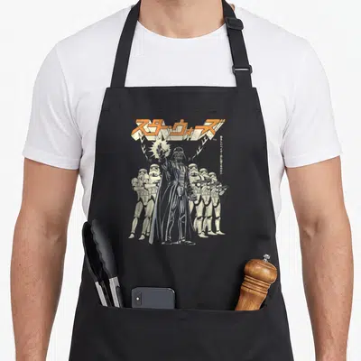 Tablier de cuisine noir avec illustration vintage de Darth Vader, Stormtroopers et logo Star Wars en caractères japonais orange.