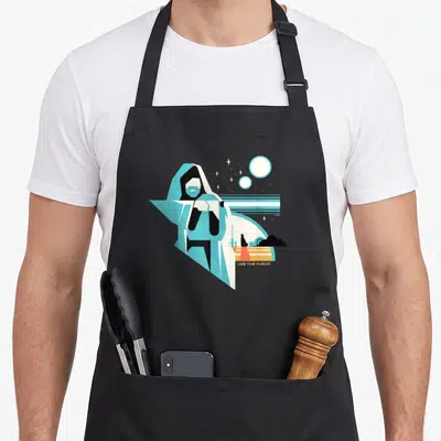 Tablier de cuisine noir avec une illustration stylisée d'Obi-Wan Kenobi et la phrase Use The Force en bas à droite.