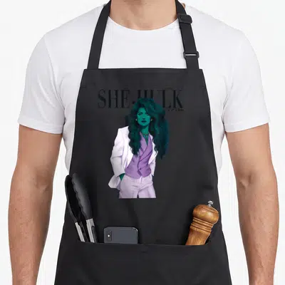 Tablier de cuisine noir avec une illustration de She-Hulk Jen Walters en costume blanc et violet sous le titre SHE-HULK JEN WALTERS.