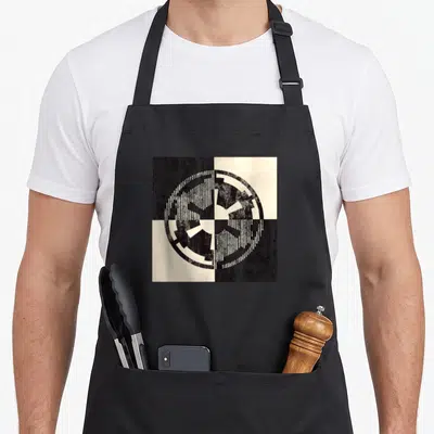 Tablier de cuisine noir avec emblème Empire divisé en quatre cases noir et crème style tamponnage vieilli.