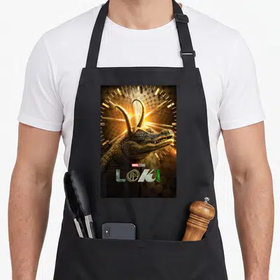 Tablier de cuisine noir avec un crocodile aux cornes dorées et le titre Loki en bas du dos.