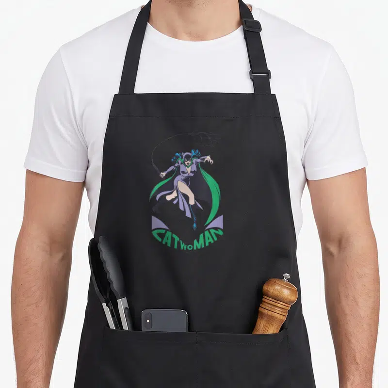 Tablier de cuisine noir avec illustration colorée de Catwoman With a Whip en mouvement dynamique.