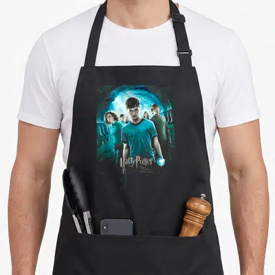Tablier de cuisine noir avec une illustration d'un groupe marchant sous un tunnel en pierre aux lumières bleutées et le titre du film en bas.