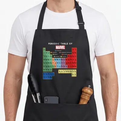 Tablier de cuisine noir avec un tableau périodique coloré des personnages Marvel et leurs équipes respectives imprimées au centre.