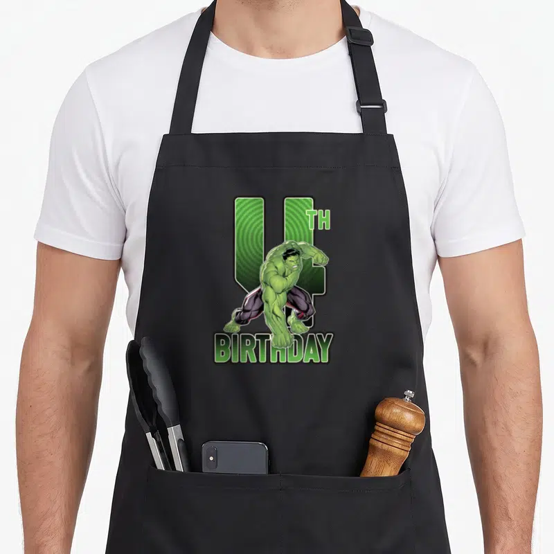 Tablier de cuisine noir avec le Hulk vert sautant devant un chiffre 4 et le mot anniversaire imprimé en bas.