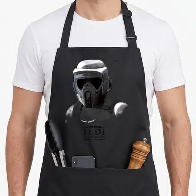 Tablier de cuisine noir avec illustration monochrome d'un soldat impérial et logo Jedi Fallen Order en bas.