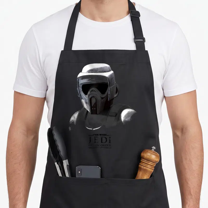 Tablier de cuisine noir avec illustration monochrome d'un soldat impérial et logo Jedi Fallen Order en bas.