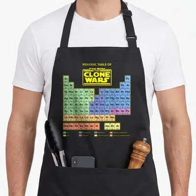 Tablier de cuisine noir avec un tableau périodique coloré reprenant les personnages de Star Wars The Clone Wars en lettres jaunes.
