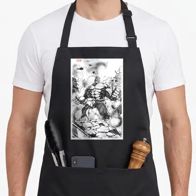 Tablier de cuisine noir avec une illustration en noir et blanc du Hulk sur fond de ruines et d'hélicoptères.