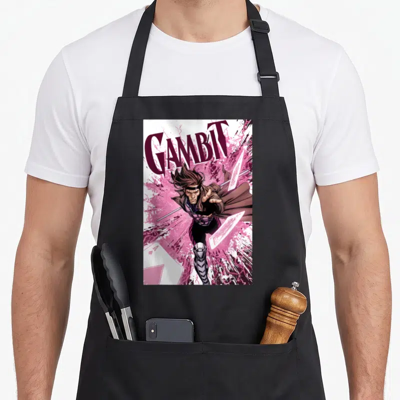 Tablier de cuisine noir avec illustration Gambit et cartes roses explosives sur fond blanc.