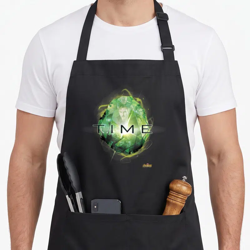 Tablier de cuisine noir avec une pierre de temps verte luminescente et le portrait du Docteur Strange au centre du design.