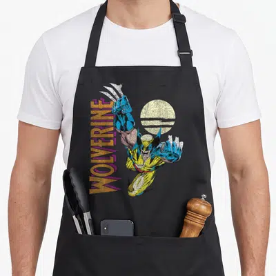 Tablier de cuisine noir avec illustration rétro Wolverine Claws Out et texte vertical orange et violet.