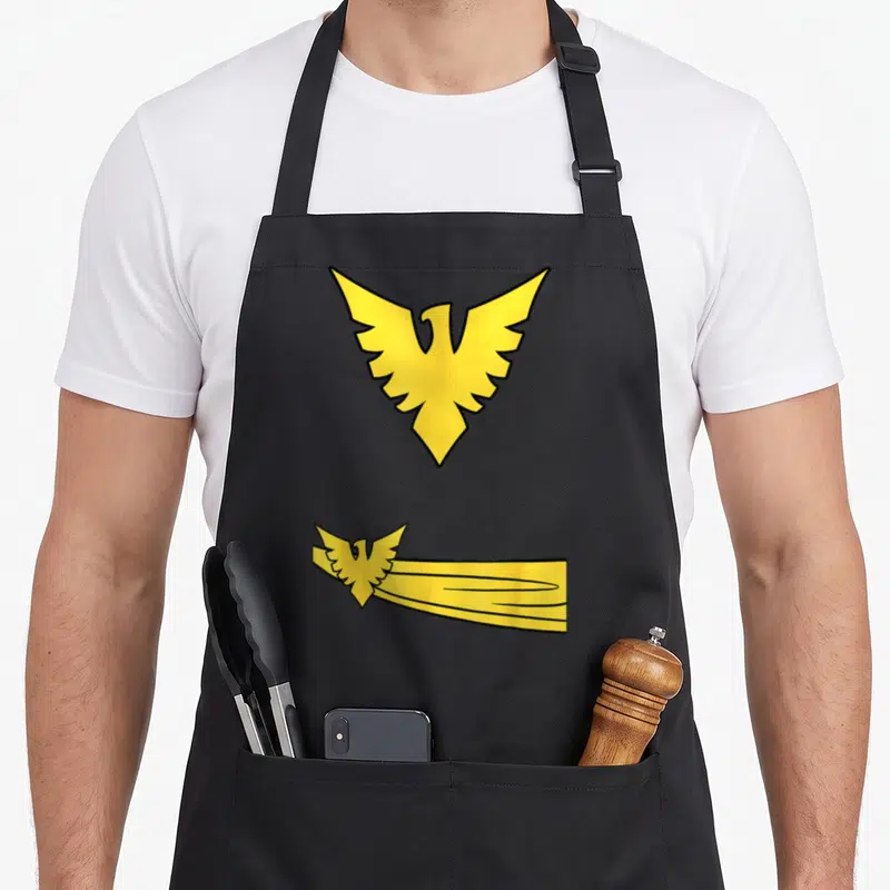 Tablier de cuisine noir avec emblème aigle doré Phoenix et traînée jaune stylisée en bas à droite.