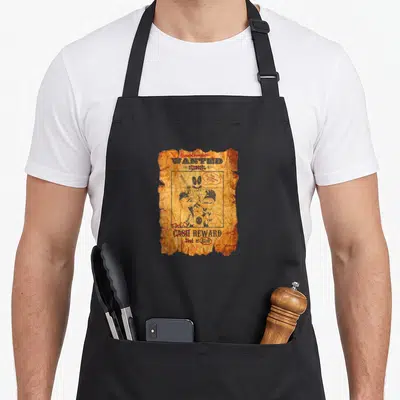 Tablier de cuisine noir avec une wanted poster Deadpool aux couleurs vieillies et texte en anglais.