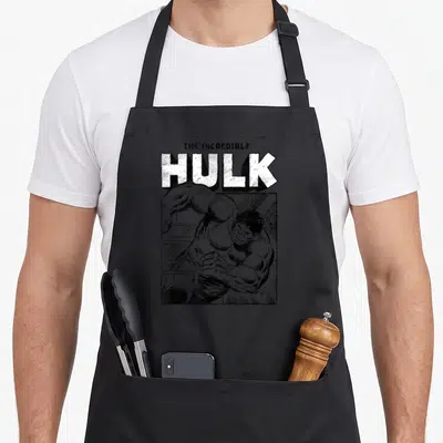 Tablier de cuisine noir avec illustration monochrome du Hulk sprintant sous le titre The Incredible Hulk en typographie épaisse.