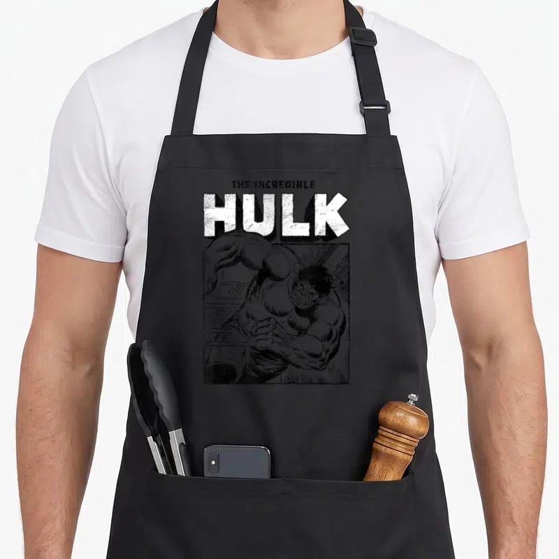 Tablier de cuisine noir avec illustration monochrome du Hulk sprintant sous le titre The Incredible Hulk en typographie épaisse.