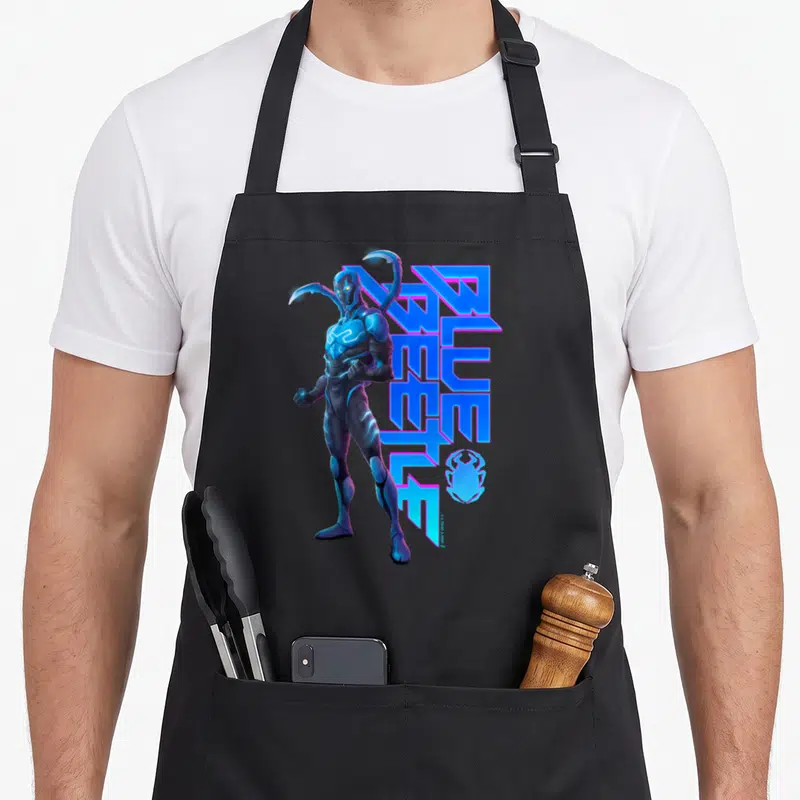 Tablier de cuisine noir avec illustration de Blue Beetle et texte stylisé bleu électrique.
