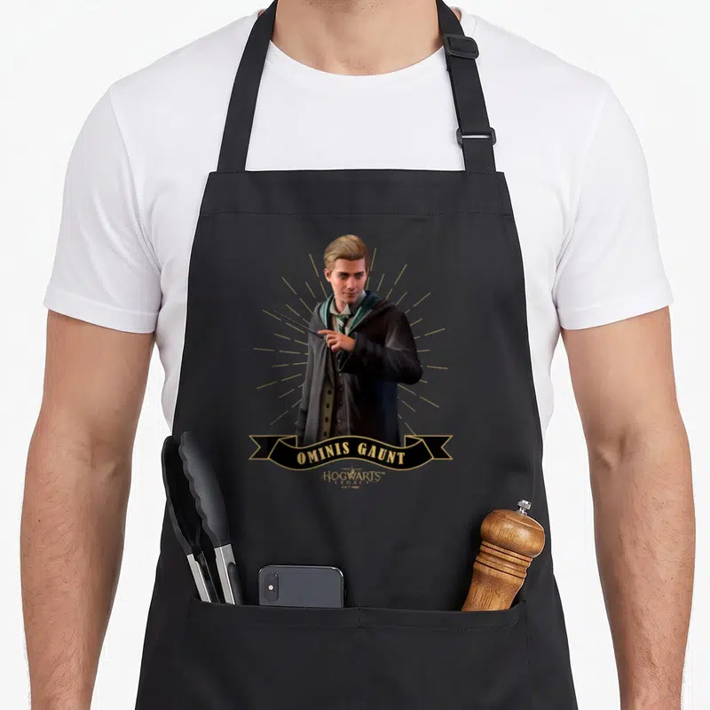 Tablier de cuisine noir avec illustration d'Ominis Gaunt et bannière Hogwarts Legacy en bas.