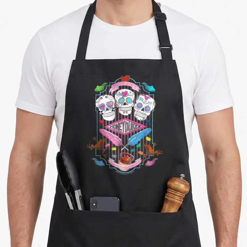 Tablier de cuisine noir avec skulls colorés plumes et étiquette Honeydukes Hogsmeade.