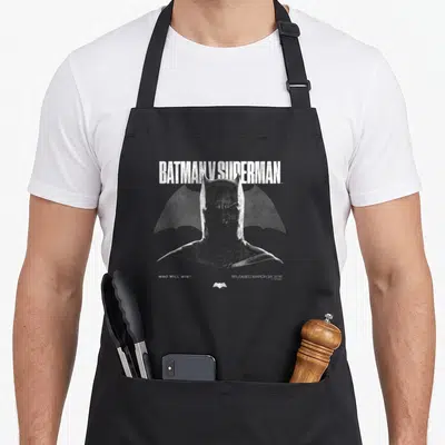 Tablier de cuisine noir avec illustration du cowl de Batman et le texte Batman v Superman en blanc.