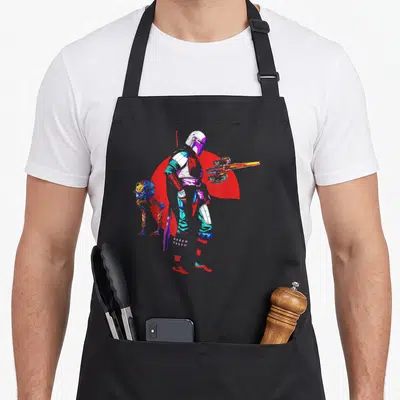 Tablier de cuisine noir avec une illustration colorée du Mandalorian tenant un blaster près d'un petit Walker robotique.
