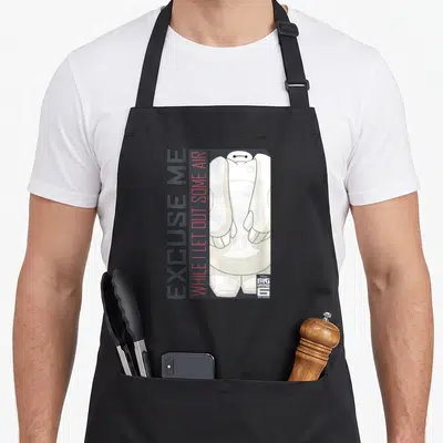 Tablier de cuisine noir avec illustration de Baymax et texte vertical Excuse Me While I Let Out Some Air en gris et rouge.